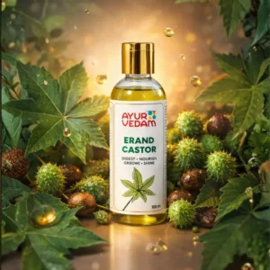 Ayurvedam Erand Castor oil bottle (100ml) featuring the words "Digest, Nourish, Grow, Shine." The bottle is set against a botanical background of green leaves and spiky castor beans with soft, golden bokeh lighting.