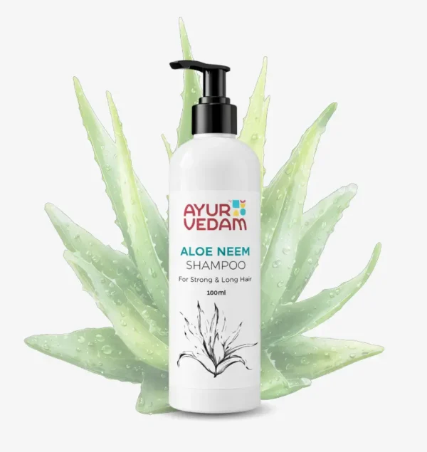 A 100ml white pump bottle of Ayurvedam Aloe Neem Shampoo for strong and long hair, pictured in front of fresh, water-droplet-covered aloe vera leaves.