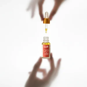 A bottle of Kumkumadi Elixir Oil by Ayurvedam - holded between two hands