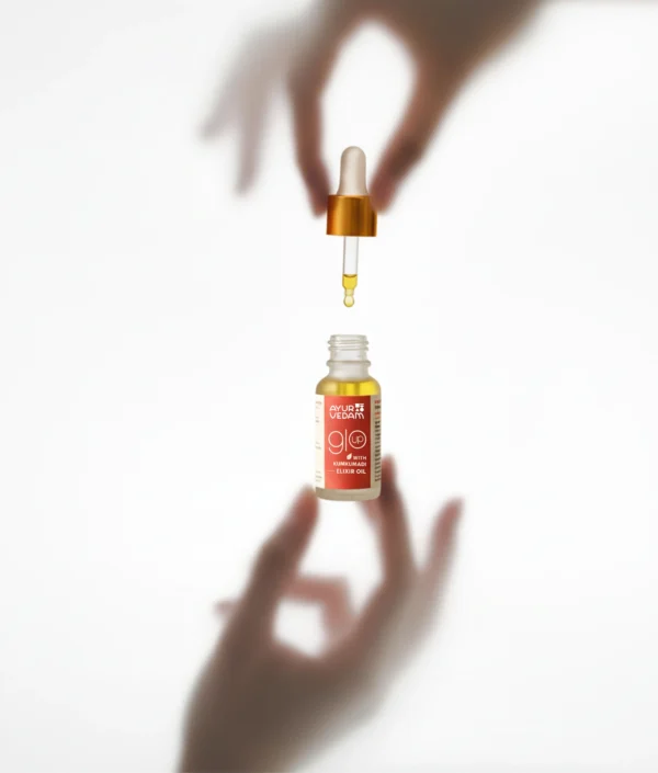 A bottle of Kumkumadi Elixir Oil by Ayurvedam - holded between two hands