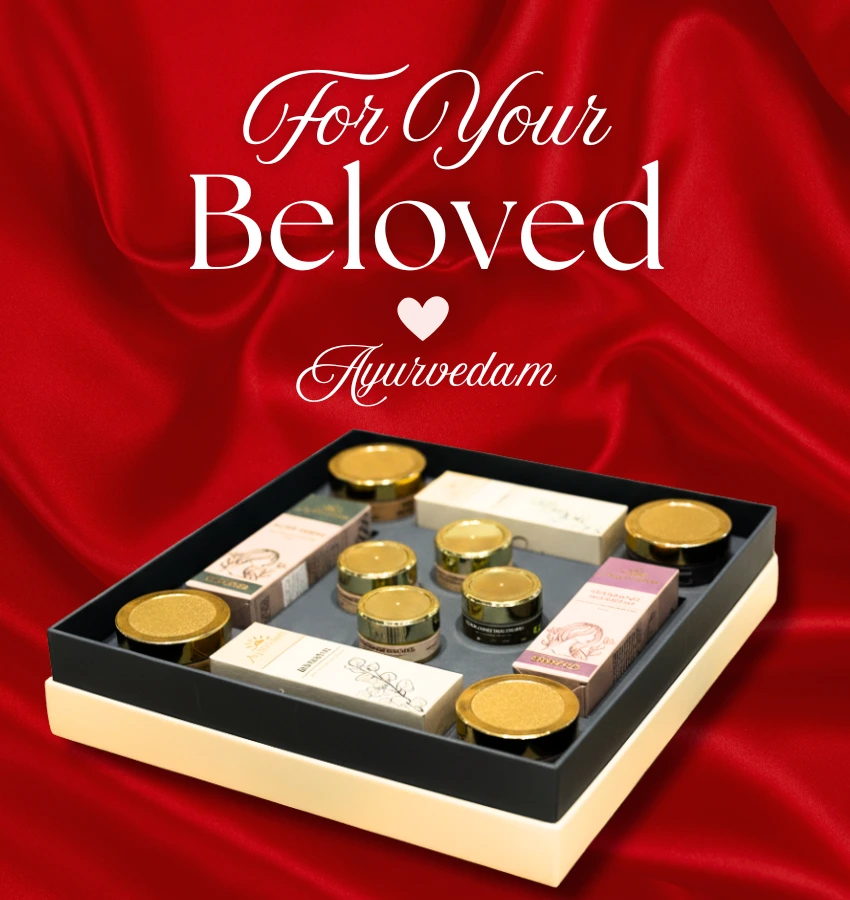 Ayurvedam branded gift box containing Ayurvedic wellness products, displayed on a natural jute surface with neem leaves, white flowers, smooth stones, clay pots, and almonds for a traditional and earthy aesthetic mobile banner.